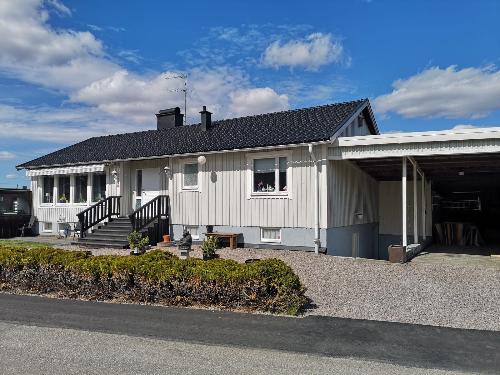 Grått hus med mörkt, nybehandlat tak