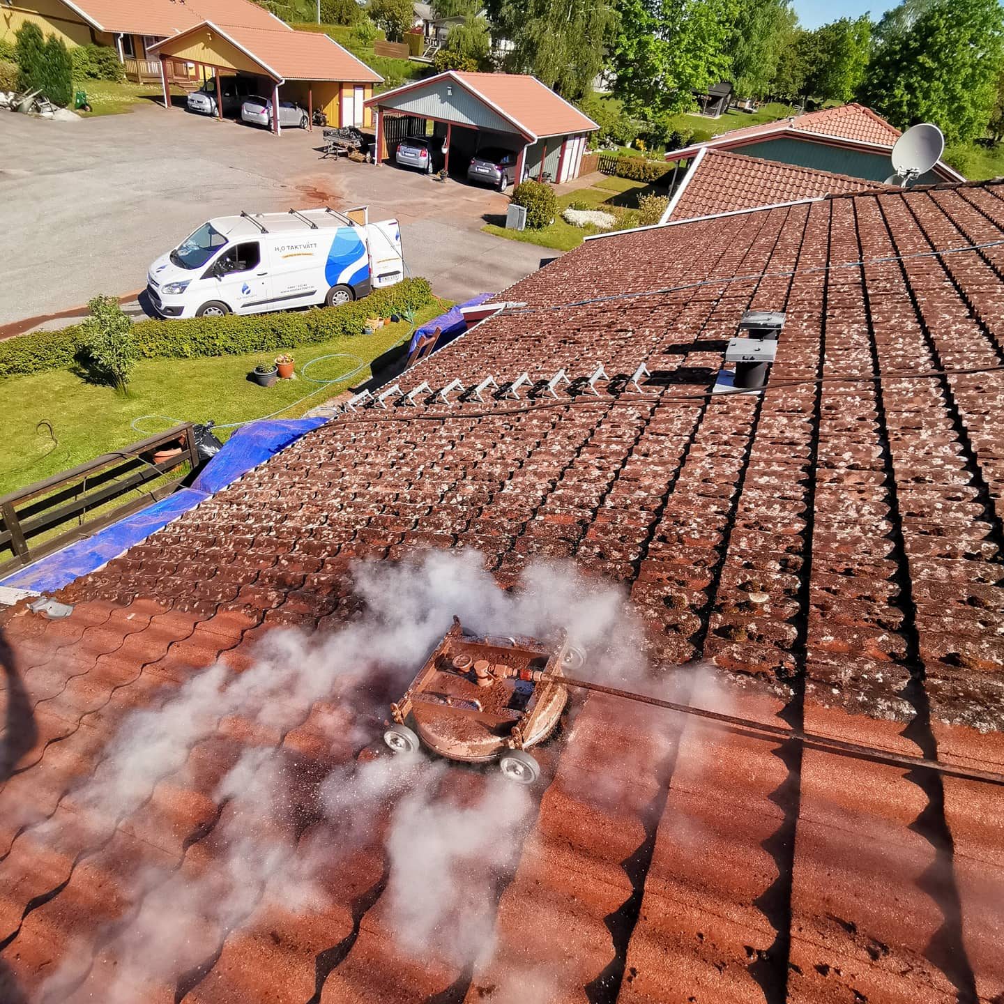 Drönarbild – takrengöring pågår med servicebil på plats
